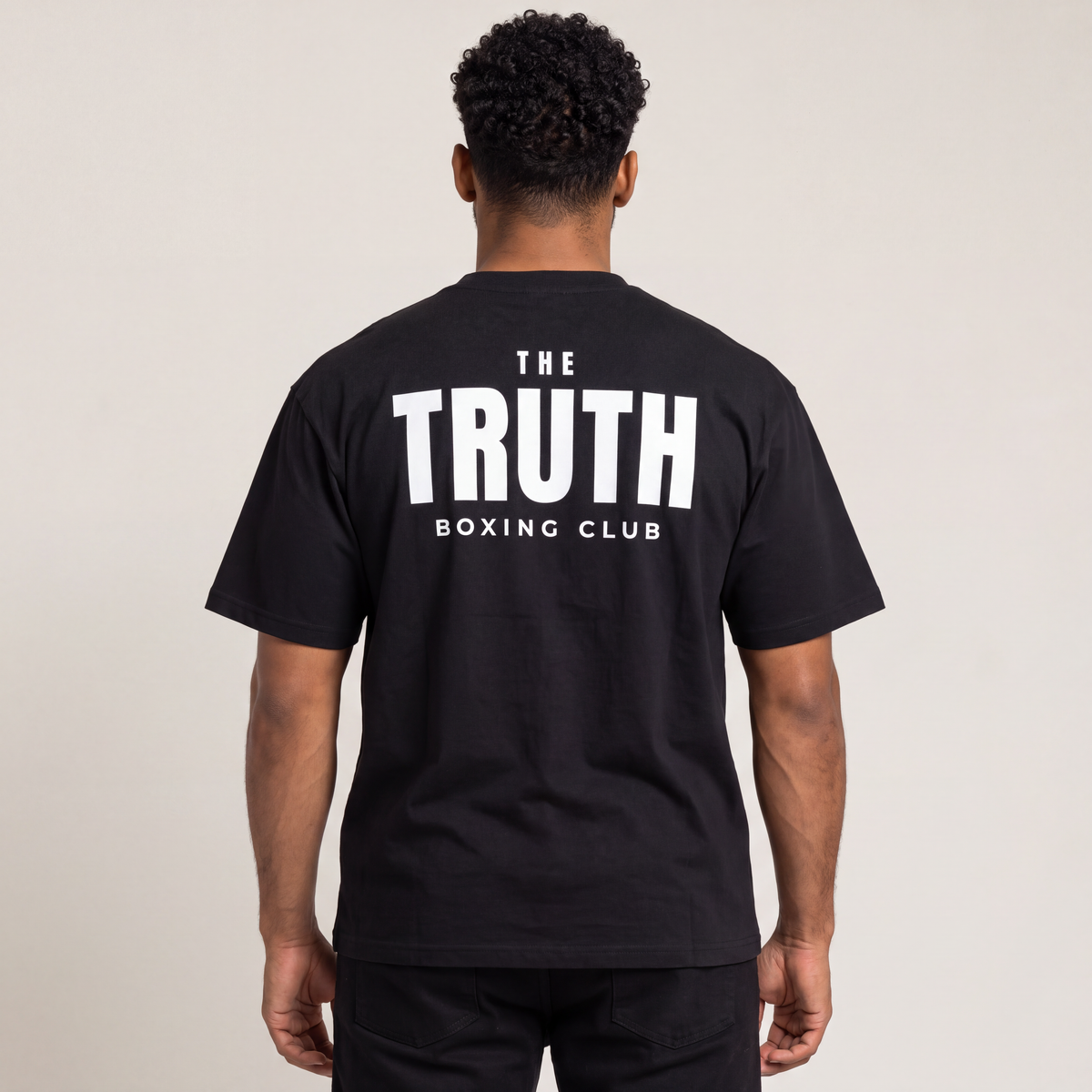 Back view of The Truth Boxing Club black tee with large white club wordmark.