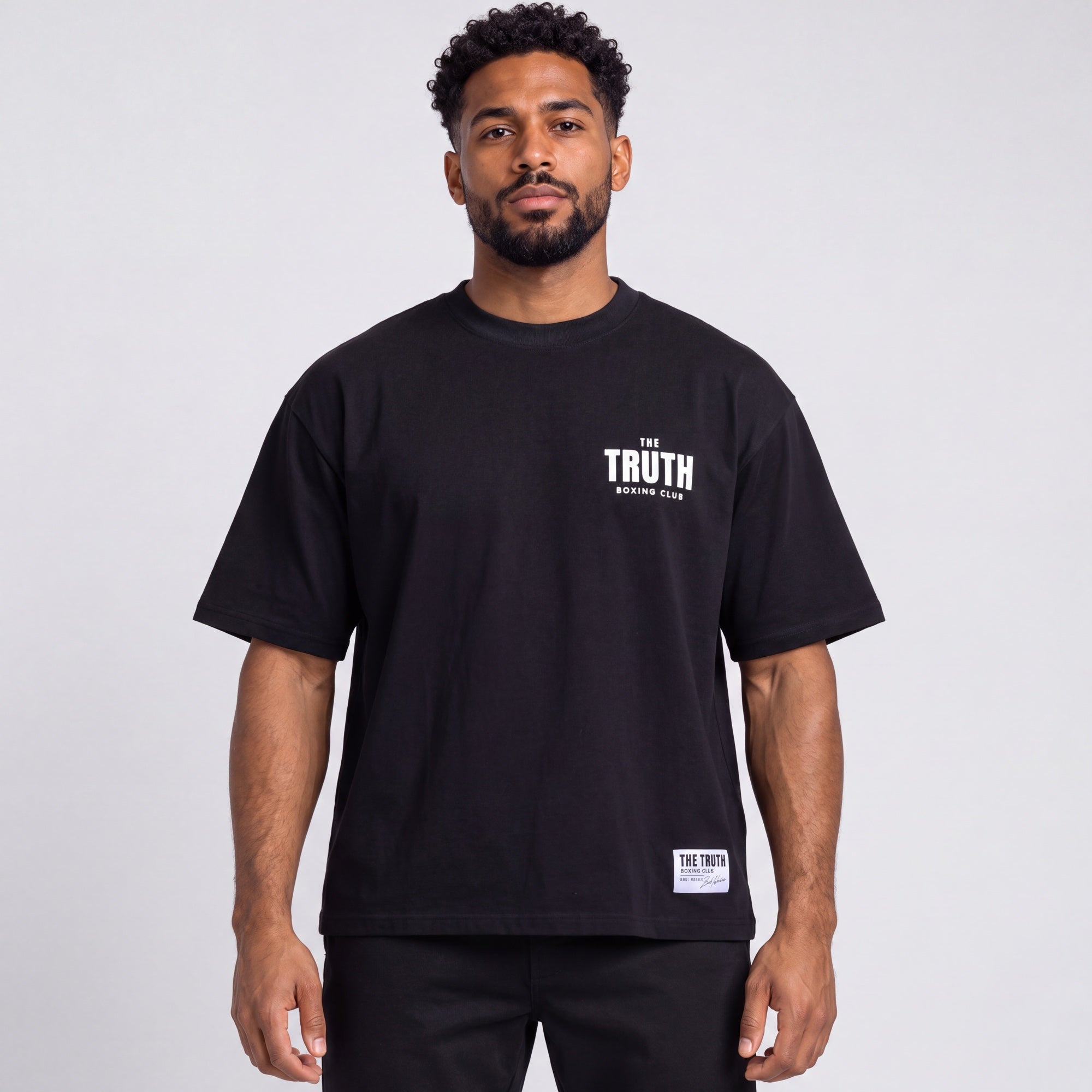 Front of the black Club Logo Tee with white chest logo and hem label